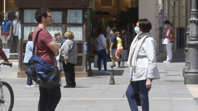 Dos personas conversan en la plaza de las Tendillas de Córdoba.