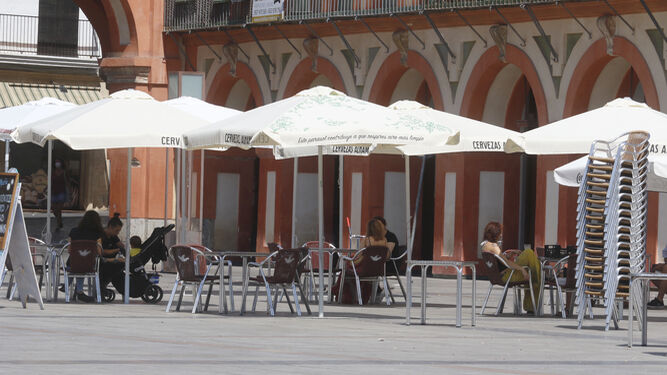 Varias personas toman algo en una terraza en la plaza de la Corredera de Córdoba.