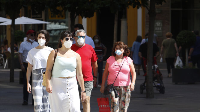 Varias personas pasean con mascarilla por una calle del Centro de Córdoba capital.