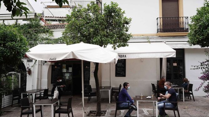 Varias personas toman algo en un restaurante cercano a la Ribera.