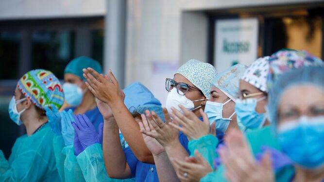 Varios sanitarios aplauden a las puertas del Reina Sofía.