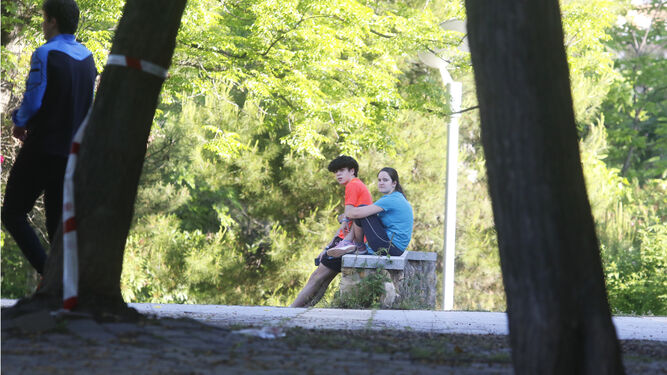 Varios jóvenes descansan en una zona de sombra en la capital cordobesa.