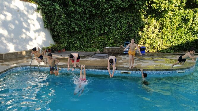 Varios jóvenes se zambullen en la piscina de la Asociación Familiar Club Alcorce.