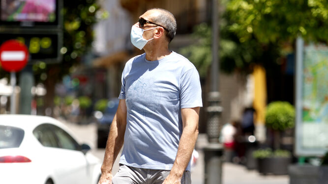 Un hombre camina con mascarilla por Córdoba.
