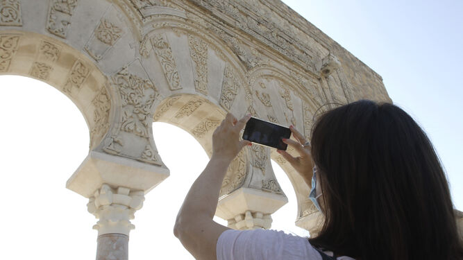 Una turista fotografía con su móvil uno de los mosaicos de Medina Azahara.