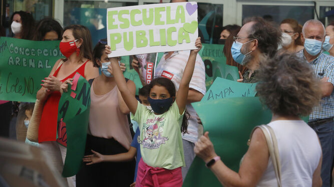 Una niña levanta un cartel en la concentración.