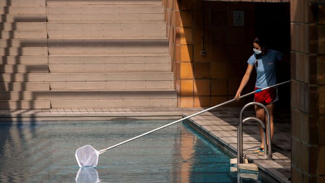 Una socorrista prepara una piscina para su apertura