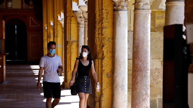 Una pareja pasea con mascarilla por la Mezquita-Catedral de Córdoba.