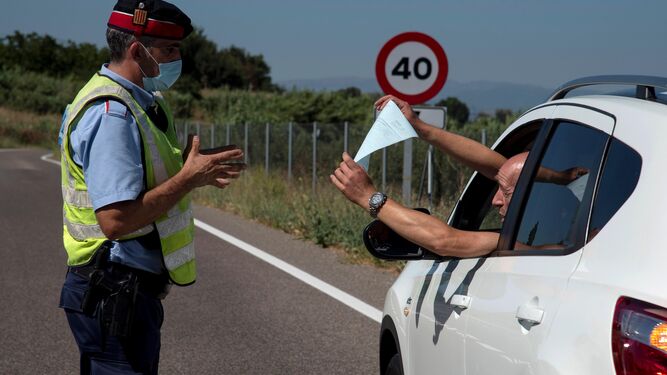 Un Mosso d'Esquadra realiza un control de carreteras en la comarca del Segrià, confinada por los rebrotes de coronavirus.