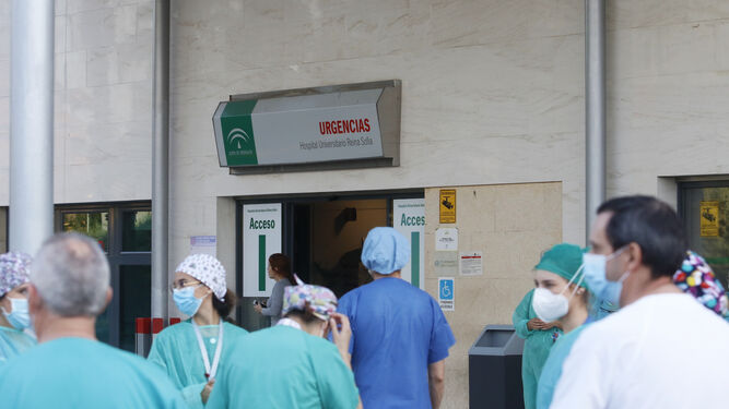 Profesionales sanitarios entran por la puerta de Urgencias.
