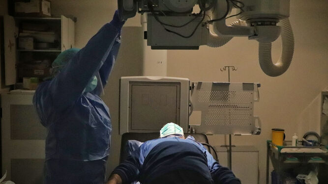 Un profesional sanitario realiza una placa a un paciente.