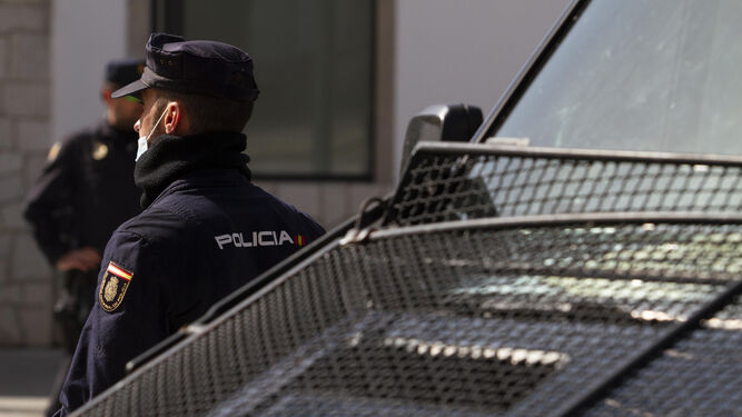 Un agente de la Policía Nacional junto a un furgón.