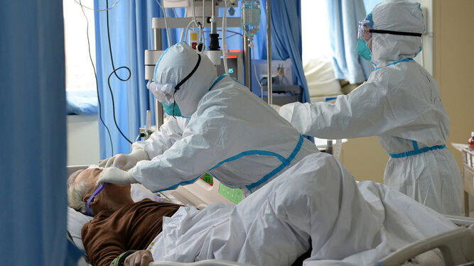 Un médico  atiende a un enfermo de coronavirus en un hospital.