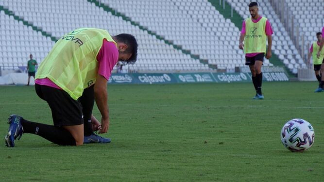 Un jugador se ata las botas durante el último partidillo del primer equipo y el filial en El Arcángel.