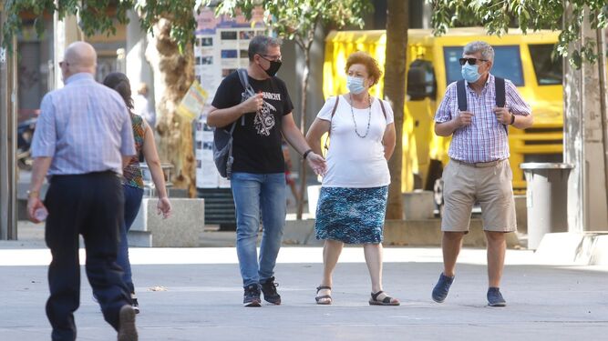 Varias personas caminan con sus mascarillas por el centro de Córdoba.