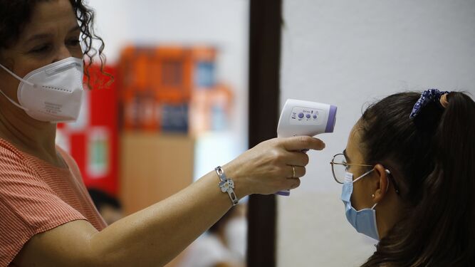 Una profesora toma la temperatura a una alumna a la llegada al colegio San Rafael del Obispo en Córdoba.
