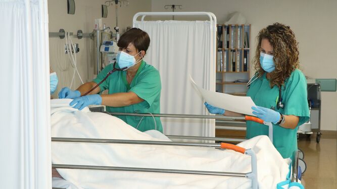 Dos profesionales sanitarias atienden a un paciente en el Hospital Reina Sofía.