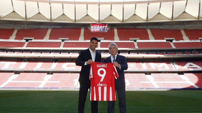 Suárez posa con la camiseta del Atlético junto al presidente del club, Enrique Cerezo