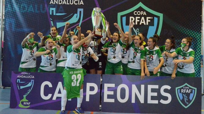 La plantilla y cuerpo técnico del Deportivo Córdoba levantan la copa de campeonas de Andalucía.