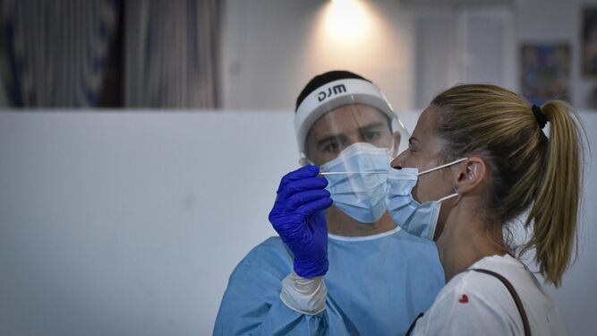Una mujer se prepara para una toma de muestras de una prueba de antígenos.