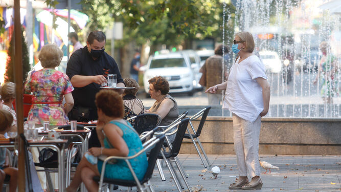 Un camarero atiende una mesa en un bar de Córdoba capital.