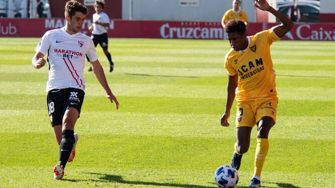 Mustafá, del UCAM Murcia, intenta superar al sevillista Peral, en la primera salida universitaria.