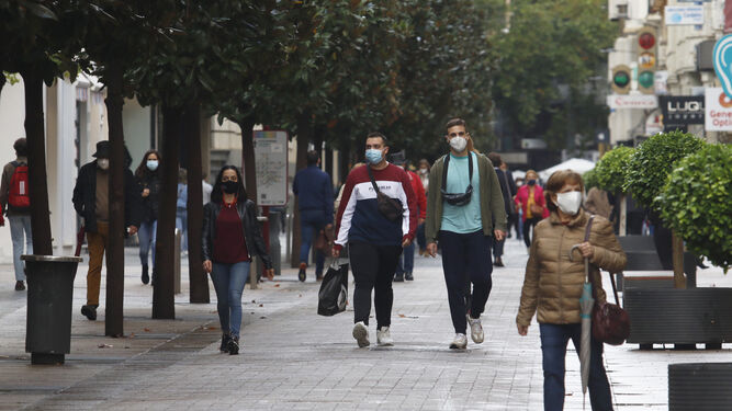 Varias personas pasean con mascarilla por el Centro de Córdoba.