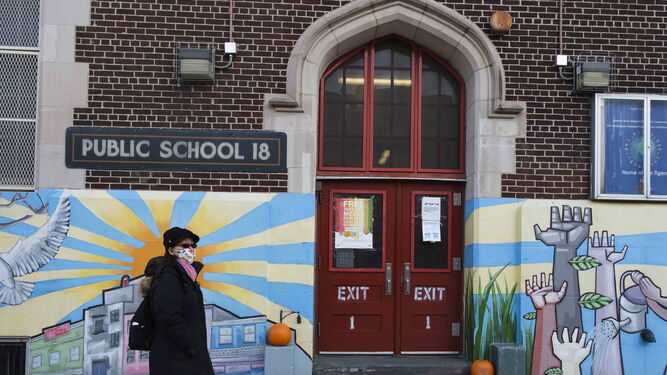 Una mujer pasea por Brooklyn delante de una escuela pública.