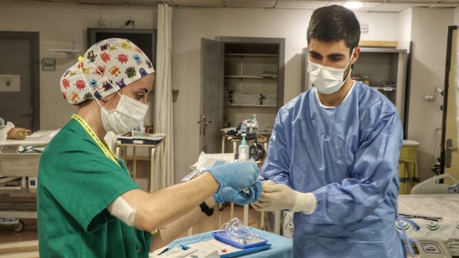 Dos profesionales sanitarios del Reina Sofía durante el tratamiento a una personas con covid.