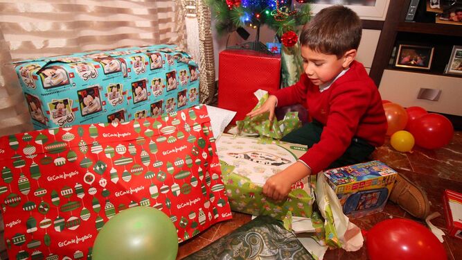 Un niño abre sus regalos de Reyes.