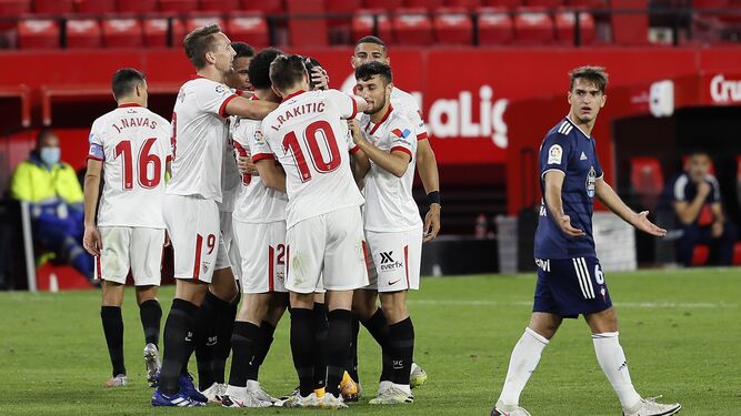 Los jugadores del Sevilla celebran un gol ante Denis Suárez, del Celta de Vigo.