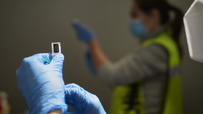 Dos sanitarios preparan vacunas contra el SARS-CoV-2.