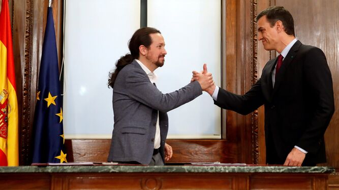 Pedro Sánchez y Pablo Iglesias estrechan sus manos tras la firma del acuerdo programático el 30 de diciembre de 2019.