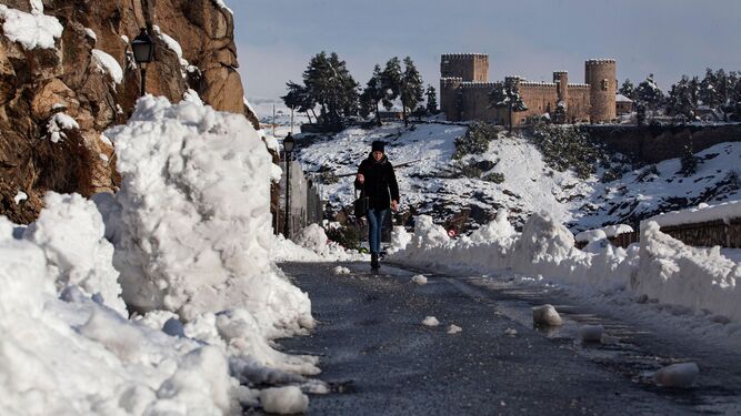 Una mujer pasea por una calle de Toledo, aun con mucha nieve y hielo.