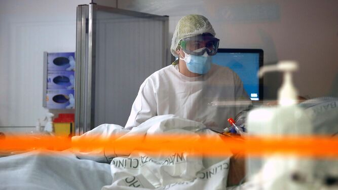 Una profesional sanitaria atiende a un paciente covid en una UCI.
