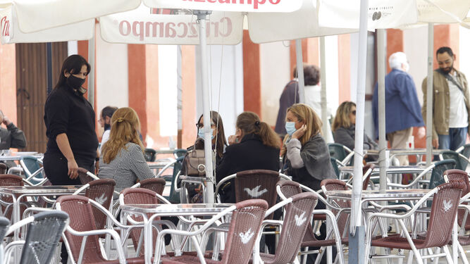 Una camarera atiende una mesa en la plaza de la Corredera de Córdoba.