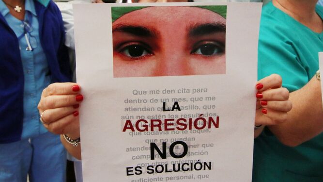 Una profesional sujeta un cartel contra las agresiones a sanitarios.
