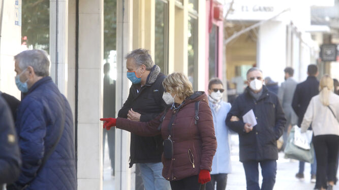 Dos personas observan el escaparate de una tienda del centro de Córdoba.