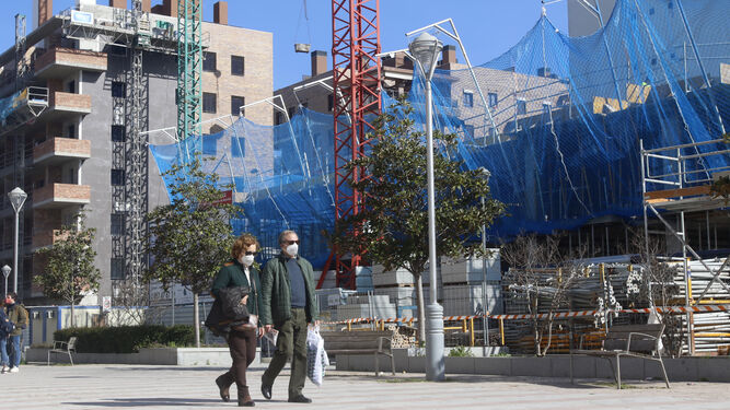 Una pareja pasea por el bulevar de Nuevo Zoco junto a la obra de una urbanización.