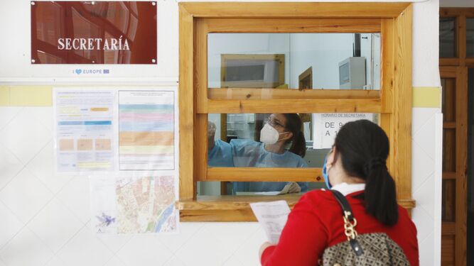 Una mujer recoge la documentación para el proceso de escolarización  en un centro de Córdoba.