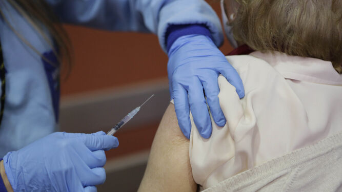 Un profesional sanitario vacuna a una persona contra el coronavirus.