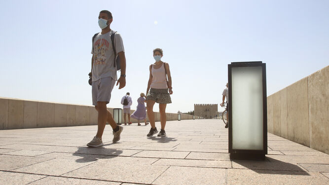 Turistas pasean por el Puente Romano de Córdoba.