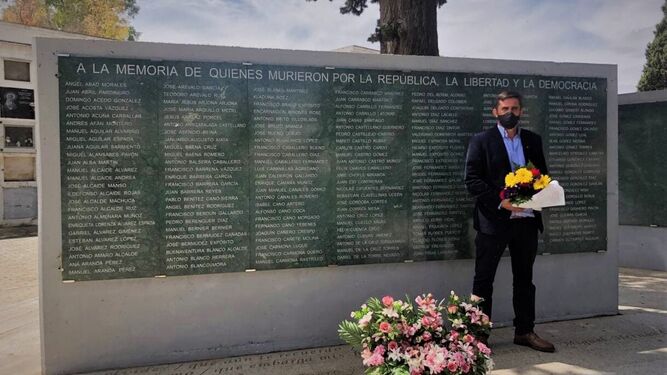 Ramón Hernández deja unas flores ante uno de los Muros de la Memoria.