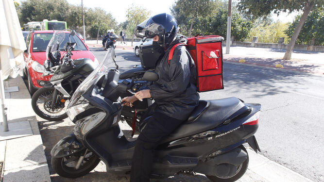 Un repartidor en moto en la zona de restaurantes de la Ribera.