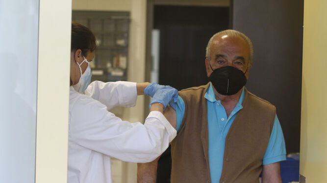 Un sanitario se prepara para administrar una vacuna a un paciente.