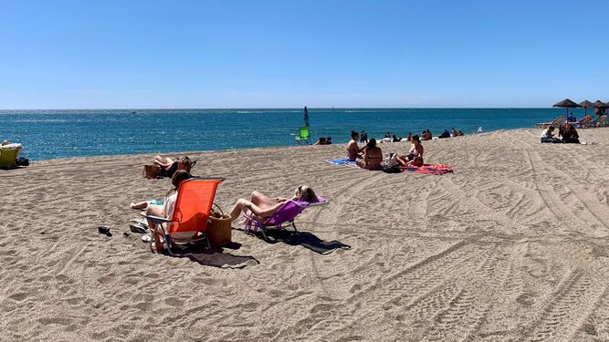 Varias personas toman el sol en la playa de Fuengirola.