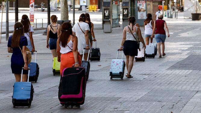 Un grupo de chicas camina con sus maletas.