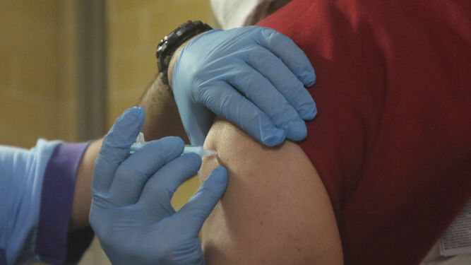 Un sanitario administra una vacuna del covid.
