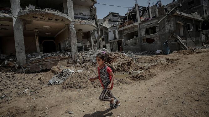 Una niña palestina corre junto a su casa destruida en Gaza.