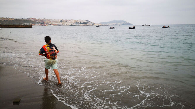Un niño observa desde la playa de Castillejos uno de los espigones de Ceuta.